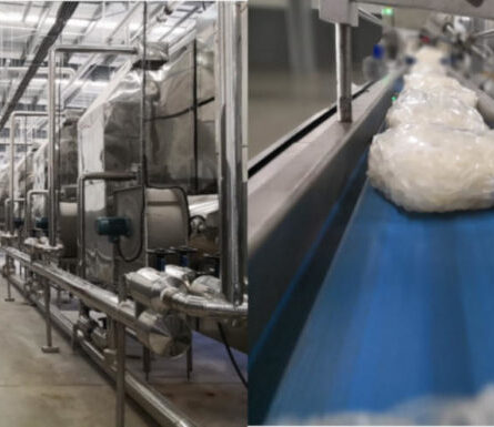 Factory production line with white sacks or ingredients. Industrial setting, food processing.